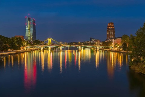 View at blue hour of the colourfully illuminated Flößerbrücke, the European Central Bank on the