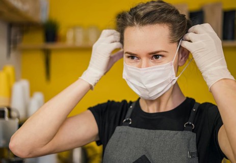 Front view female barista putting medical mask