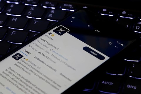 Symbolic image social media, close-up of a smartphone on an illuminated computer keyboard with X