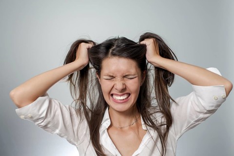 Woman with headache and negative face expression