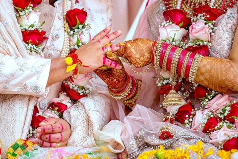 Indian bride passing wedding ring on her grooms finger on her wedding ceremony, Mauritius, Africa