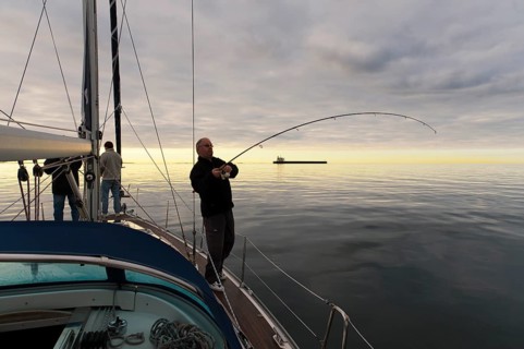 Deep-sea angler on the deck of a sailing yacht