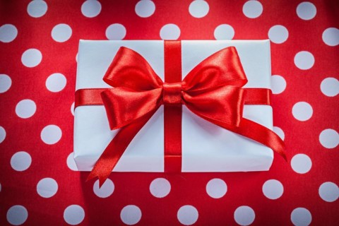 Present box on polka-dot red fabric celebrations concept
