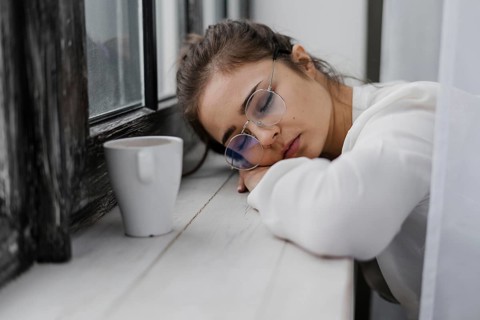 Tired businesswoman resting her head window sill