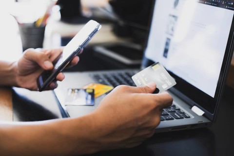 A man online shopping at home using credit card, Mobile phone and laptop for online shopping,