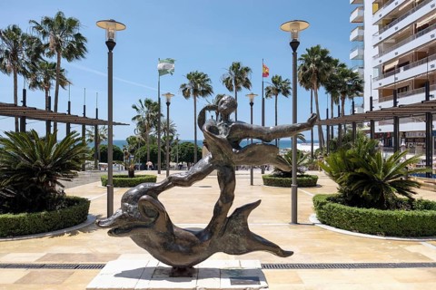 Man Above Dolphin Statue by Salvador Dali in Marbella