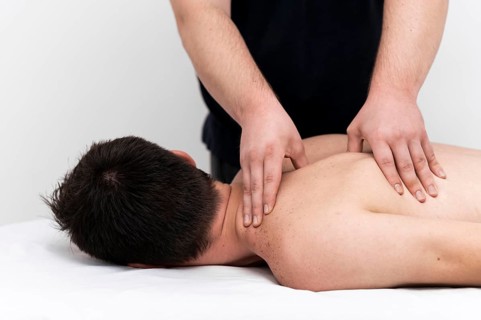 Man being given back massage by physiotherapist