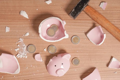 broken Piggy bank smashed into pieces - flat lay with hammer and small or loose change euro coins