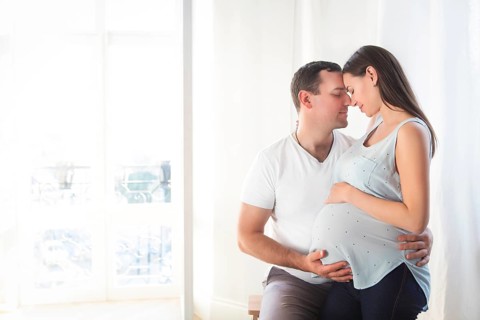 Pregnant woman and young man together indoors