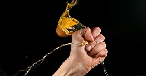 Hand of woman with a Chicken Egg against Black Background