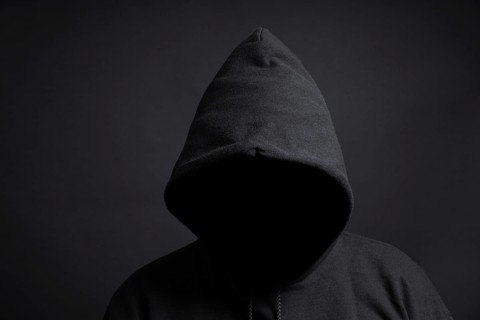 faceless person wearing black hoodie hiding face in shadow