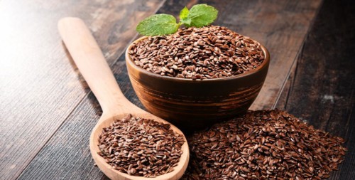 Composition with bowl of flax seeds on wooden table
