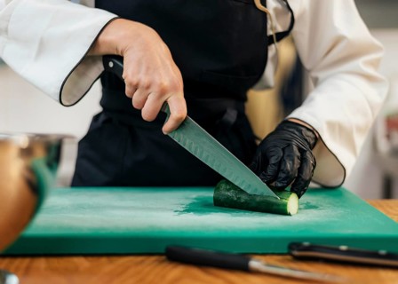 Front view female chef slicing cucumber