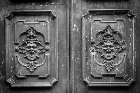Gothic mask on an old wodden door in Milan - Italy