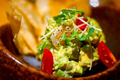 Fresh avocado and shrimps salad with nachos on side