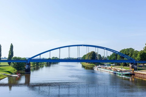 Barge loaded with bulk cargo lying in harbour on the river Weser with railway bridge (Hoya), Lower