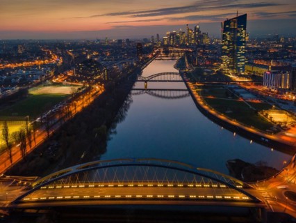 The lights of the European Central Bank (ECB) and the Frankfurt banking skyline glow in the evening