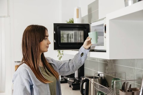 Casual girl using microwave heat cup. Resolution and high quality beautiful photo