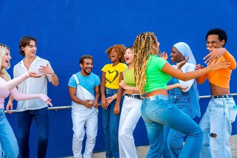 Group of young people dancing together outdoors in a multicultural party