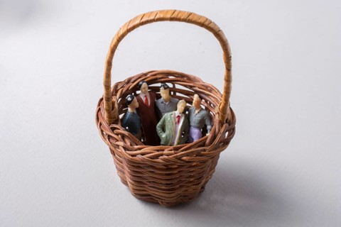 Tiny figurine of group of men miniature model in basket
