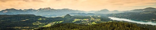 Panorama of Alpine mountains near Lake Worthersee and Velden city. Travel destination in Austria