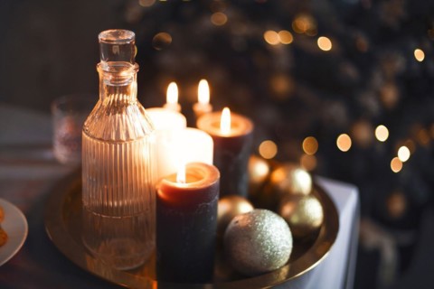 New Year's still life. Glasses and a decanter from transparent glass, candles and golden xmas balls
