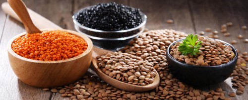 Composition with three sorts of lentils on wooden table