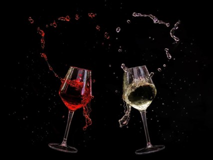 Two clinking wine glasses with red and white wine splashing out, captured in dynamic movement
