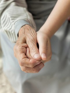 Close up granddaughter holding grandmothers hand. Beautiful photo