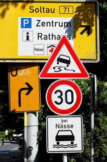 Traffic sign Maximum permitted speed 30 kilometres per hour in wet conditions, risk of skidding,