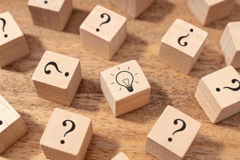 Creative idea and innovation concept. Wooden blocks with question mark symbol and light bulb