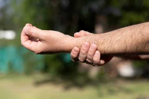 Close-up of man massaging his wrist