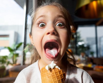 Surprised girl eating ice cream close up