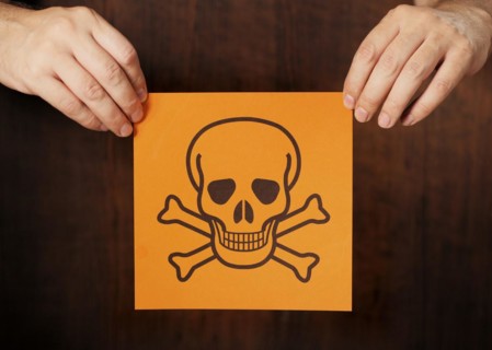 Man holding a warning sign for poison