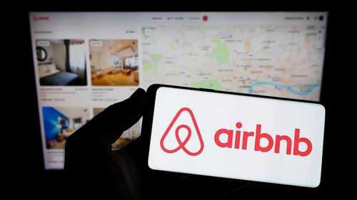 Stuttgart, Germany, 11-30-2022: Person holding cellphone with logo of American homestay marketplace