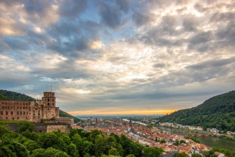View over an old town with castle or palace rune in the evening at sunset. This town lies in a