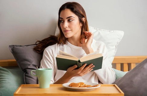 Front view woman reading having breakfast home