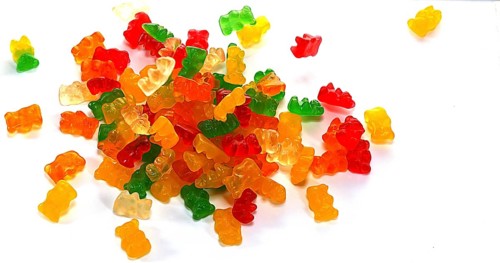 Gold Bears or Gummy Bears falling against White Background