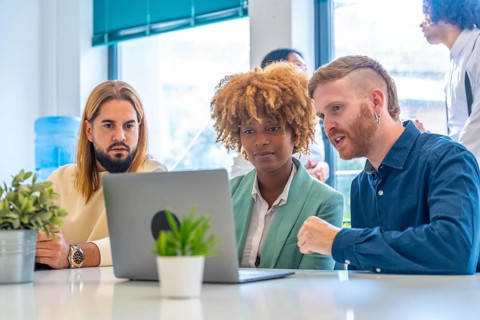 Close-up of concentrated coworkers using laptop in the office