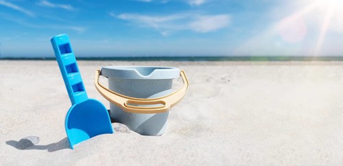 close-up view of toy bucket and spade on sand beach against sea and blue sky