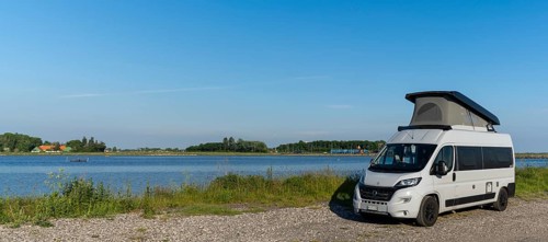 Tars, Denmark - 10 June, 2021- gray camper van parked on a gravel road at the ocean shore of