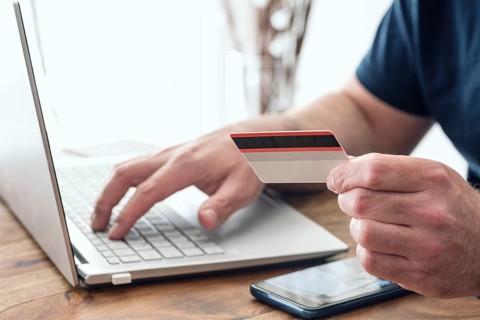 person using credit card and laptop computer for online shopping and payment, e-commerce concept