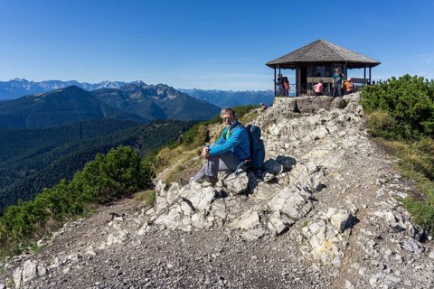 Hiker, senior, 64, resting in front of pavilion of King Ludwig II on the Herzogstand, Walchensee,