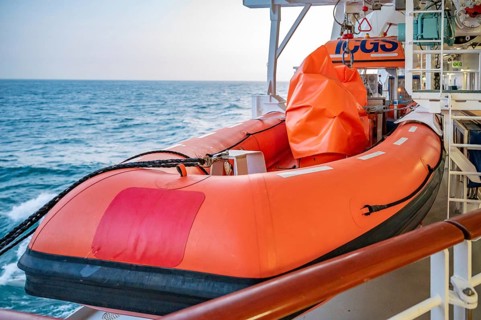 Orange AIDA Bella Cruise Ship lifeboat attached to the ship during sunset