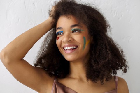 Beautiful happy african american ethnicity woman with creative art makeup looking aside with