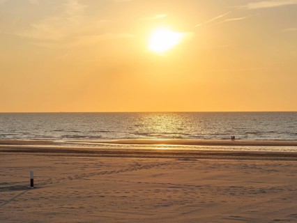 Quiet sunset on the beach with calm sea and a golden sky, oostende, belgium