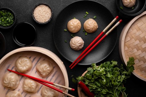 Top view asian dumplings with chopsticks herbs