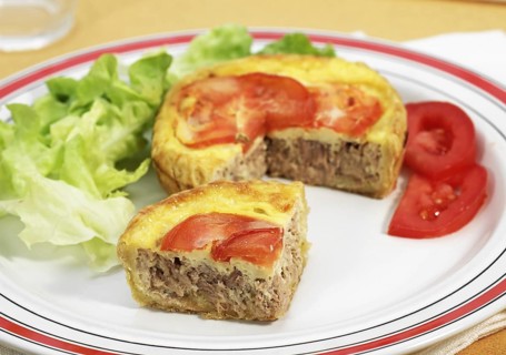 Tuna quiche with tomato and salad in plate