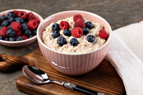 prepared oatmeal with berries on a wooden table
