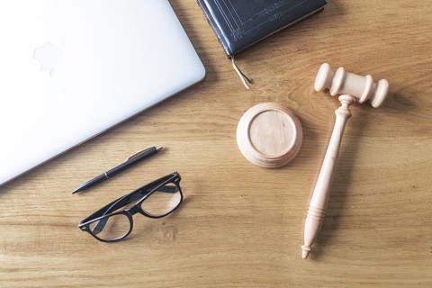 High angle view of laptop spectacles gavel and pen on wooden background on wooden desk